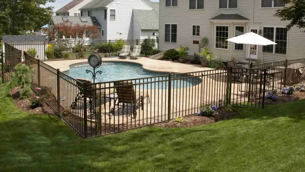 Aluminium tubular pool fence surrounding an outdoor swimming pool
