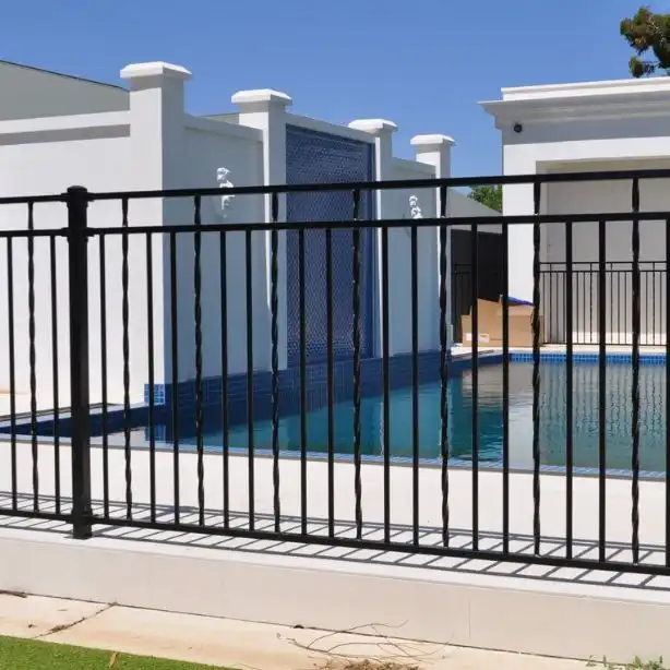 Black tubular steel security fencing around an industrial facility